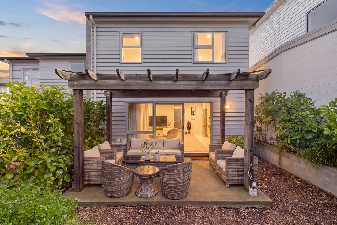 The covered outdoor living area at 55 Nautilus Drive, Gulf Harbour, lit at dusk